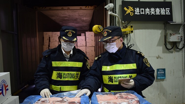 Les agents des douanes inspectent les produits de porc congel&eacute;s import&eacute;s.&nbsp;Cr&eacute;dit photo : Jiang Songqi
