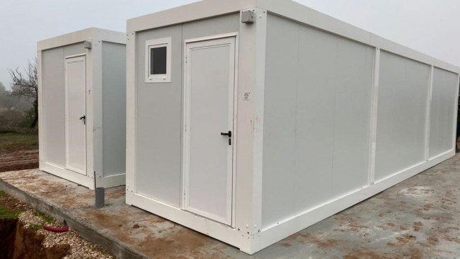 Foto 1: Esempio di locali prefabbricati sul perimetro esterno di un allevamento, prima di entrare nell'area circostante gli edifici di produzione (foto per gentile concessione di Ramaderies Miqueló).